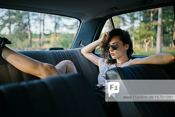 Porträt eines Hipster-Mädchens auf dem Rücksitz eines Autos.