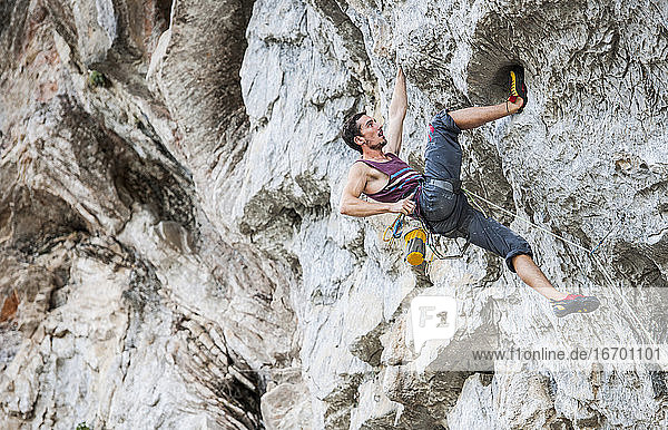 young man climbing overhang in Yangshuo / China