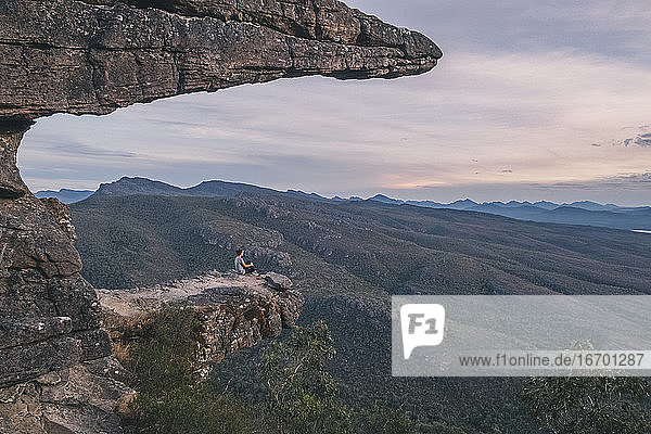 Woman sits at the Balconies and looks the landscape of the Grampians National Park  Victoria  Australia