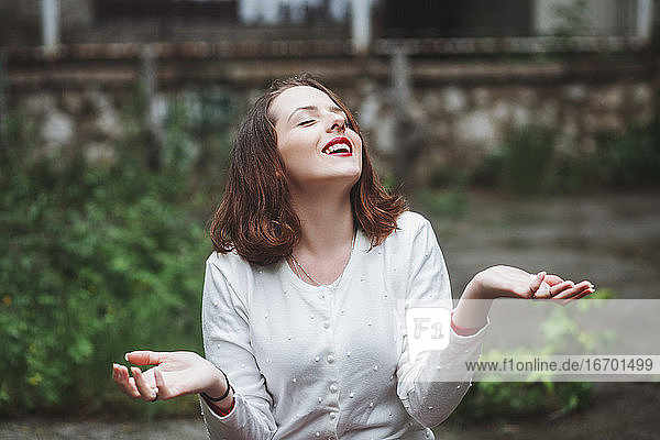 Junge Frau lächelt im Regen