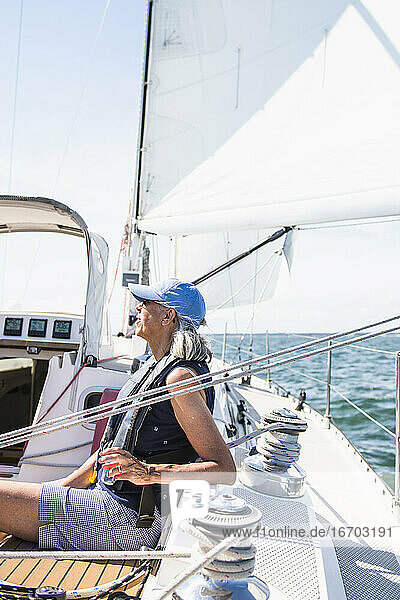 Middle aged woman enjoying family sail on sunny summer day