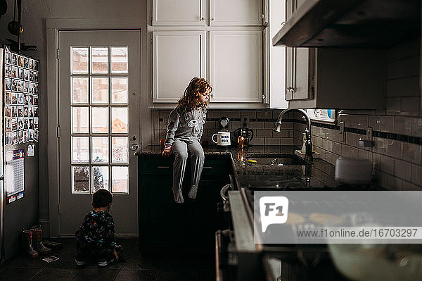 Junges Mädchen und Junge im Schlafanzug  die in der Küche beim Frühstückmachen helfen