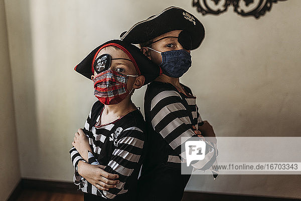 School age brothers dressed as pirates with face masks on