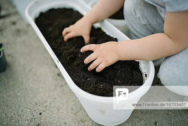 Ein kleines Mädchen hat Spaß im Garten und hält ein Gartengrundstück
