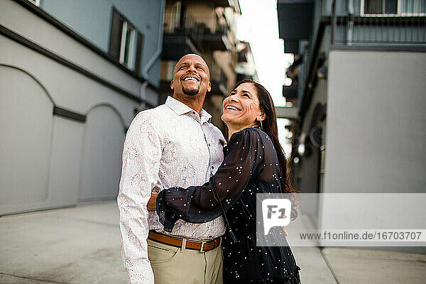 Spätes vierzigjähriges Paar  das lachend in einer Gasse in San Diego steht