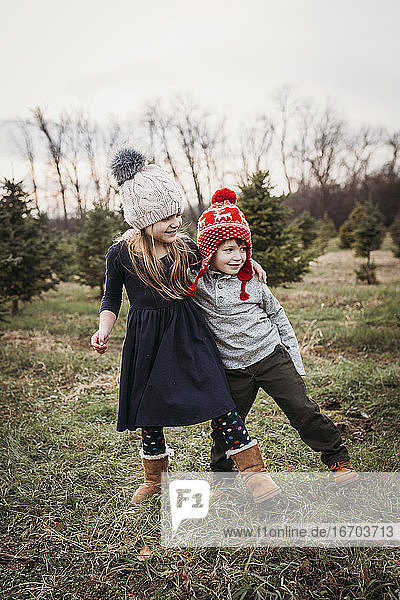 Junge und Mädchen auf dem Weihnachtsbaumhof