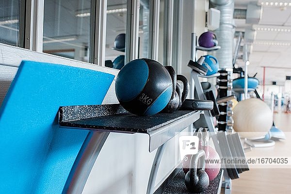 Medizinbälle auf einem Ständer in einem Fitnessstudio voller Fitnessgeräte