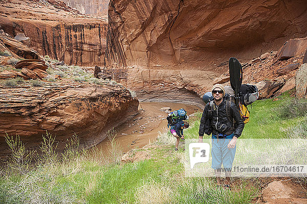 Packrafters wandern im Coyote Gulch  Utah  nachdem sie den Escalante River hinuntergefahren sind