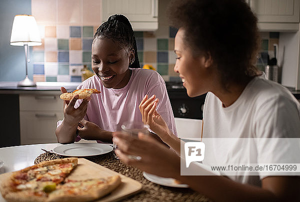 Diverse women eating delivery pizza