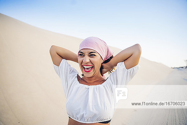 Junge Frau mit rosa Kopftuch kämpft gegen Krebs