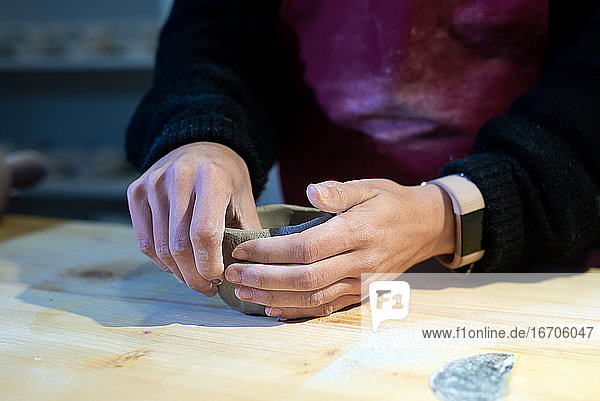 Junge Keramikerin beim Formen einer Keramikschale in einer Töpferwerkstatt