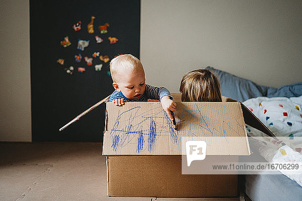 Kinder spielen und malen in einer Box während des Einschlusses