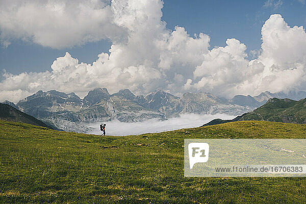 Junger Mann wandert auf dem Berg Aspe in den Pyrenäen  während er seinen Sohn trägt.