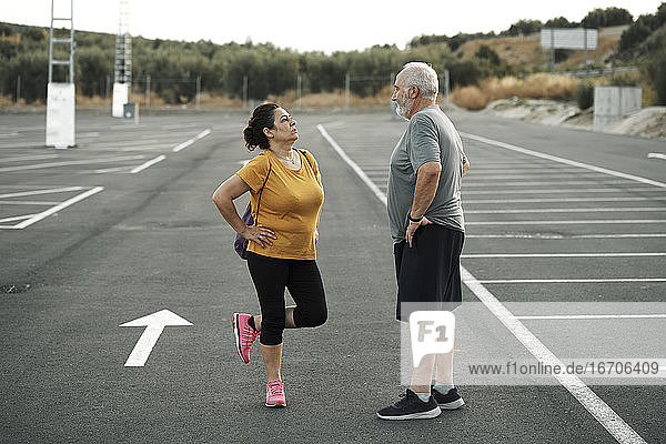 A middle-aged man and woman get ready to exercise
