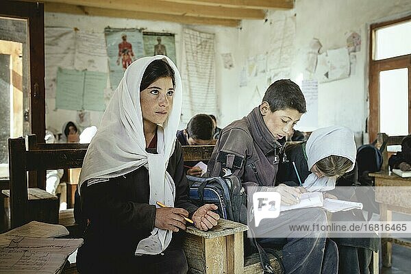 Drei Schüler in einer Schulbank  Klassenzimmer  Potokh Primary School  Potokh  Wakhan-Korridor  Afghanistan  Asien