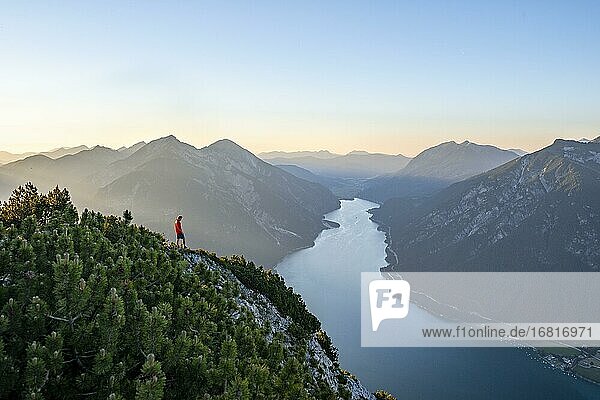 Junger Mann blickt über Berglandschaft  Ausblick vom Gipfel des Bärenkopf auf den Achensee  links Seekarspitze und Seebergspitze  Karwendel  Tirol  Österreich  Europa