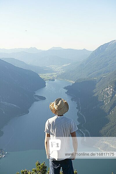 Young man looks over mountain landscape  summit of the Bärenkopf  view of the Achensee  Karwendel  Tyrol  Austria  Europe
