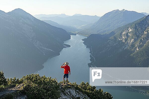 Young man looking over mountain landscape  view from the top of the Bärenkopf to the Achensee  left Seekarspitze and Seebergspitze  Karwendel  Tyrol  Austria  Europe