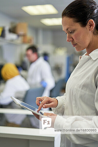 Wissenschaftlerin mit digitalem Tablet im Labor