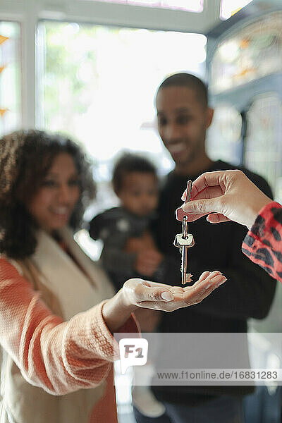 Familie erhält neue Hausschlüssel vom Immobilienmakler