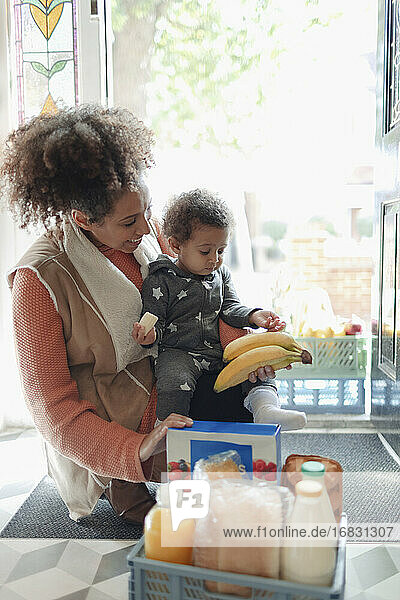 Mutter und Baby Tochter erhalten Lebensmittel Lieferung an der Haustür