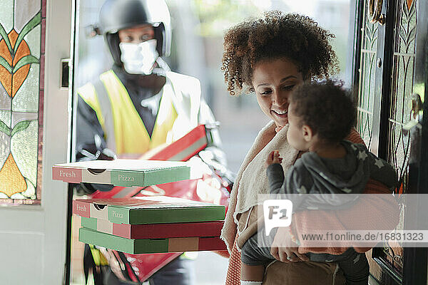 Mutter und Baby Tochter erhalten Pizzalieferung an der Haustür