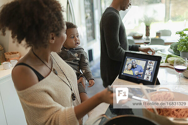 Familie kochen Abendessen und Video-Chat durch digitale Tablette in der Küche