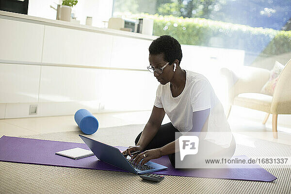 Frau arbeitet und übt auf Yogamatte zu Hause
