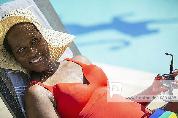Porträt glückliche reife Frau in Sonnenhut Sonnenbaden am sonnigen poolside