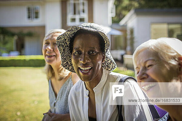 Portrait happy senior women friends in sunny summer backyard