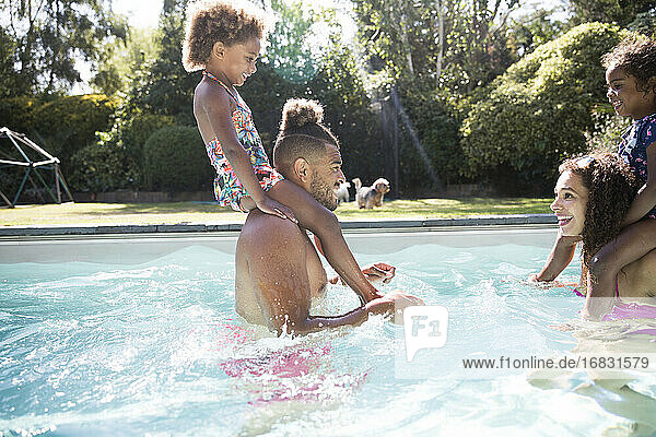 Familie spielt im sonnigen Sommer Schwimmbad