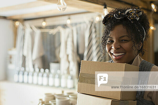 Porträt glückliche weibliche Ladenbesitzerin trägt Kisten