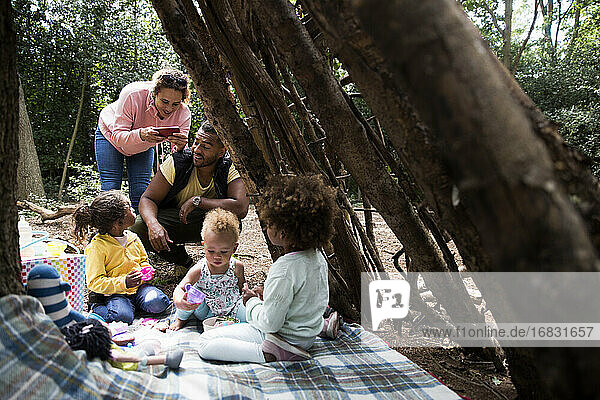 Glückliche Familie spielt Tee-Party in Baum Fort im Wald