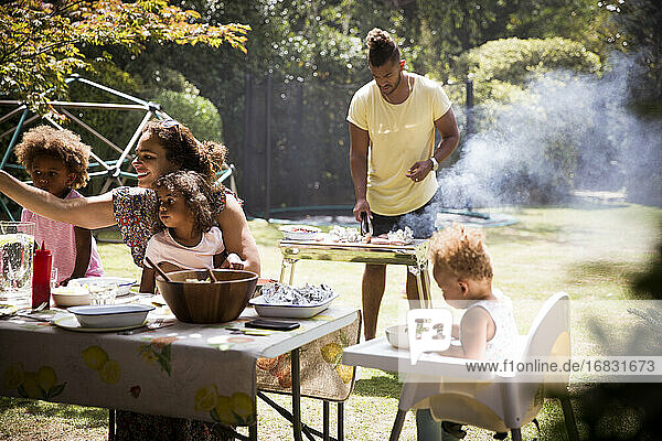 Familie Grillen und Essen auf sonnigen Sommer Hinterhof Terrasse