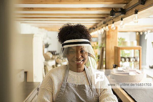 Porträt glückliche weibliche Ladenbesitzerin mit Gesichtsschutz