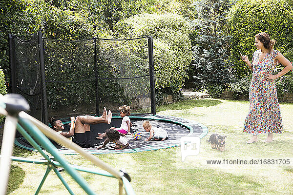 Familie spielt auf sonnigen Hinterhof Trampolin