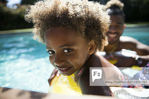 Porträt niedlichen Mädchen mit lockigem Haar in sonnigen Sommer Schwimmbad