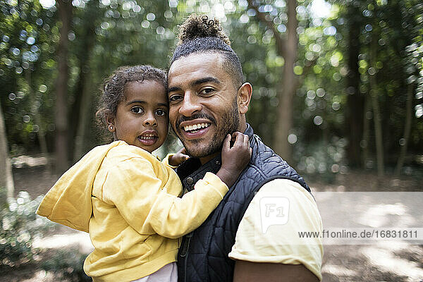 Portrait glücklicher Vater und Tochter im Wald