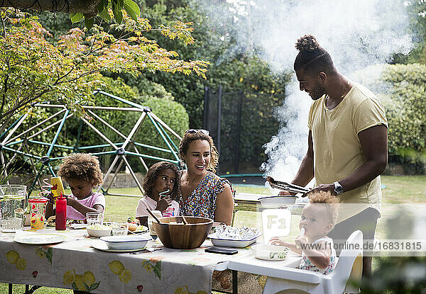 Glückliche Familie genießt Sommer Barbecue auf der Terrasse Tisch