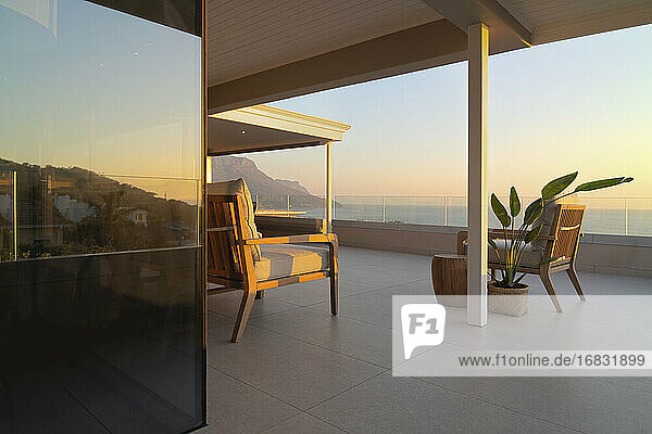 Luxuriöse Musterhaus-Terrasse mit ruhigem Blick auf den Sonnenuntergang am Meer
