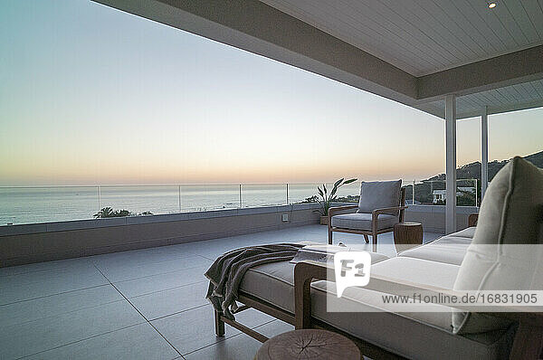 Luxuriöse Musterhaus-Terrasse mit malerischem Meerblick bei Sonnenuntergang