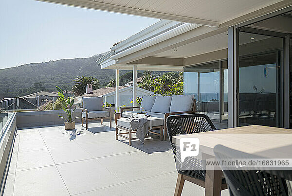 Esstisch und Sofa auf der sonnigen Home-Showcase-Terrasse