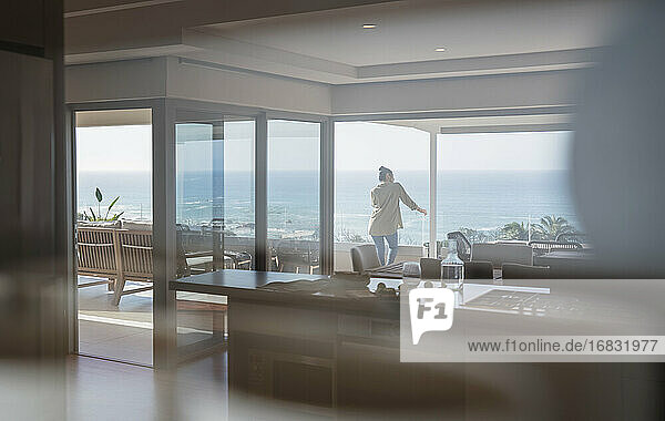Frau mit Blick auf sonnigen Blick auf das Meer auf Luxus nach Hause Schaufenster Balkon