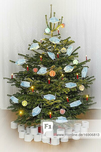 Christmas tree decorated with face masks. Under the Christmas tree are toilet paper rolls as presents. Theme image for Christmas 2020 during the corona pandemic  symbol image  25.11.2020.  Offenbach am Main  Hesse  Germany  Europe