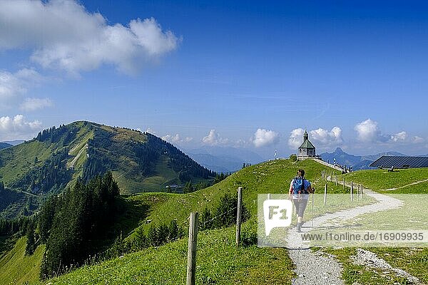 Hiker in front of the Wallberg church Heilig Kreuz  Wallberg church on Wallberg  Upper Bavaria  Bavaria  Germany  Europe