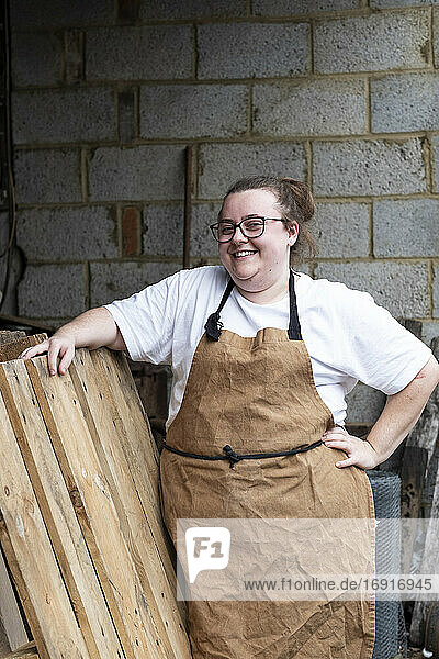 Porträt einer Bäckerin im Freien  Hand in die Hüfte gestemmt  in die Kamera lächelnd.