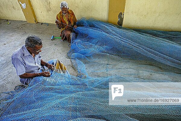 Jaffna,  Sri Lanka - February 2020: Men repairing nets in the fishing district of Jaffna on February 23,  2020 in Jaffna,  Sri Lanka.