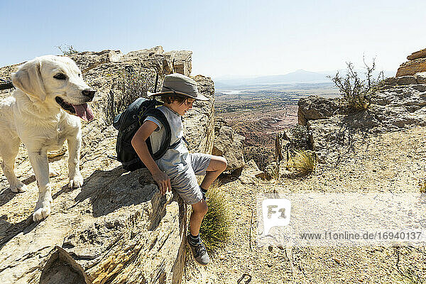 young boy hiking with his dog on Chimney Rock trail  through a protected canyon landscape
