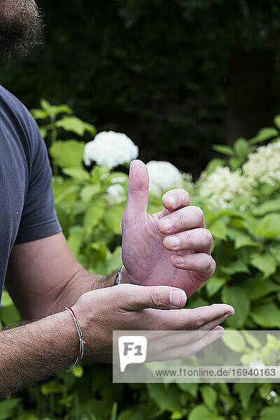 Nahaufnahme der Hände eines Mannes  zusammen und drückende Meridianpunkte an den Händen  Therapie
