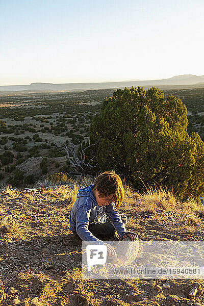 young boy in Galisteo Basin at sunset with his English Cream Golden Retreiver